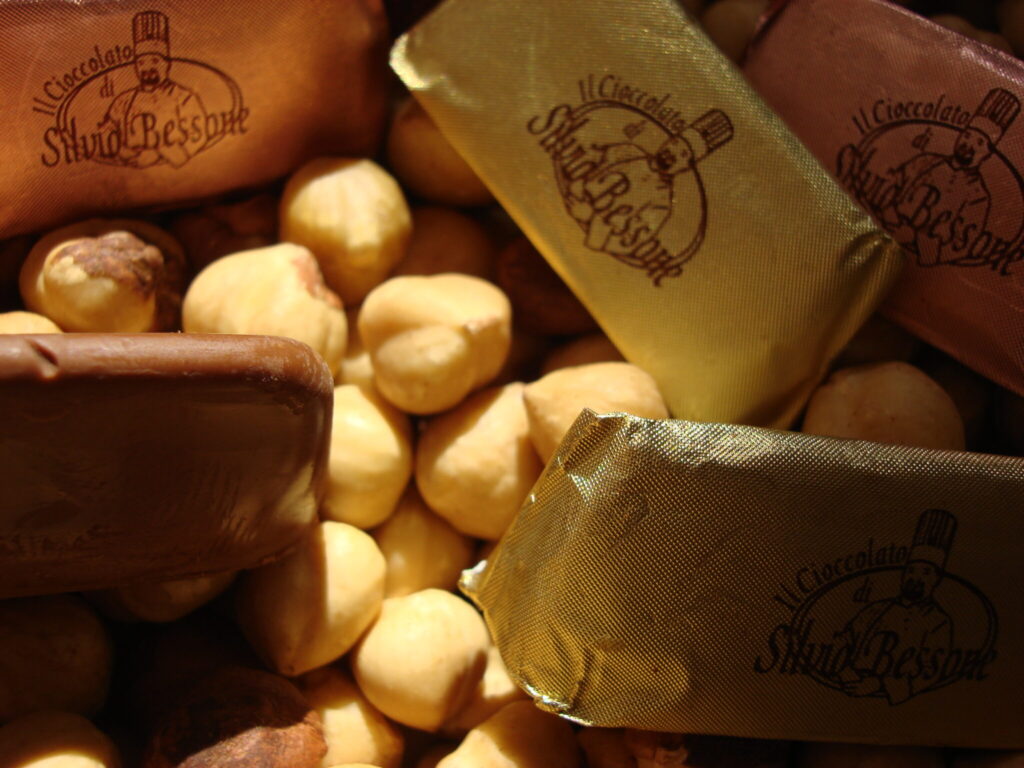 Giandujotti di Silvio Bessone avvolti in carta dorata e marrone, con nocciole Piemonte in primo piano.